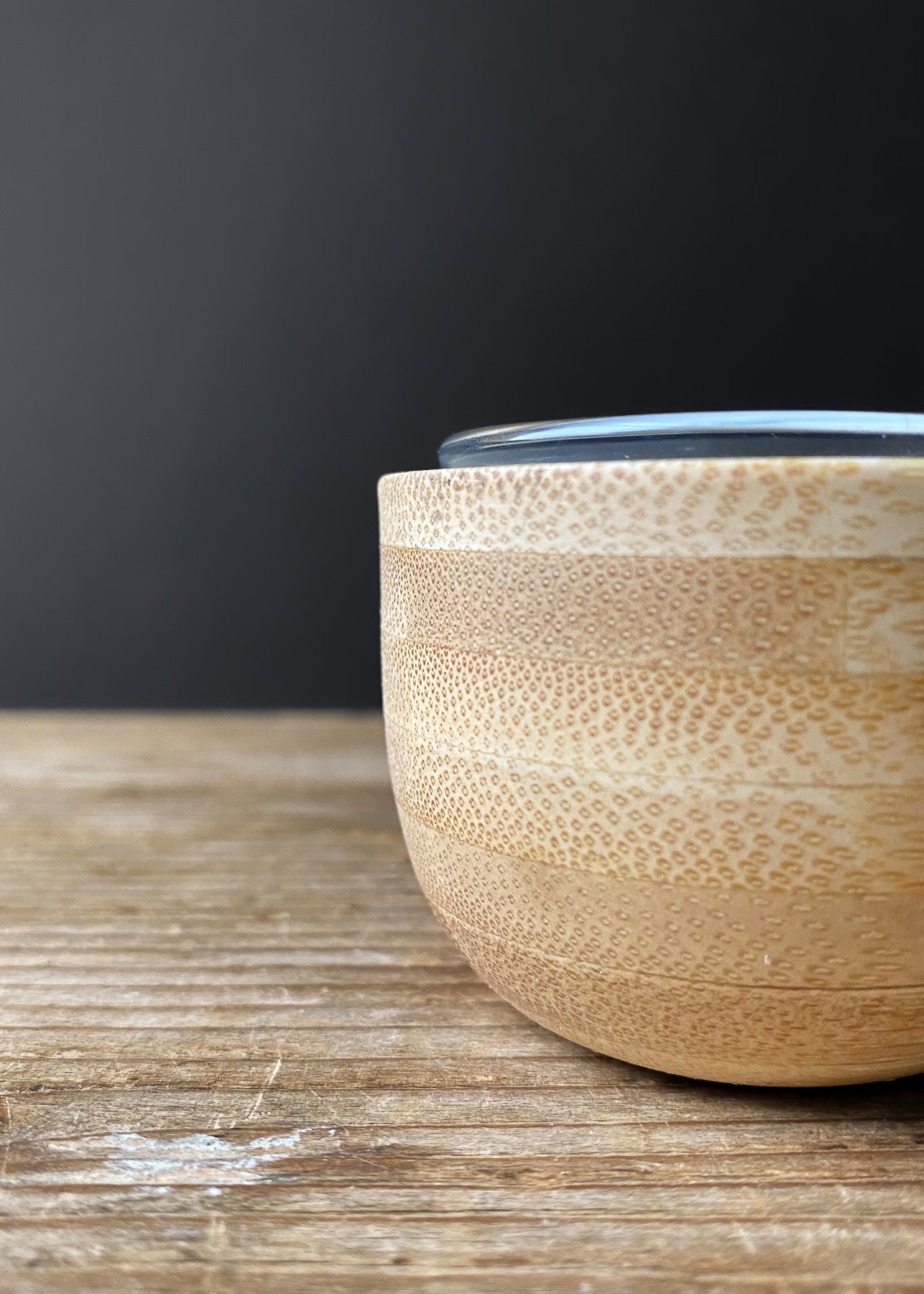 Close-up of a bamboo candle holder with a clear glass insert showing natural grain.