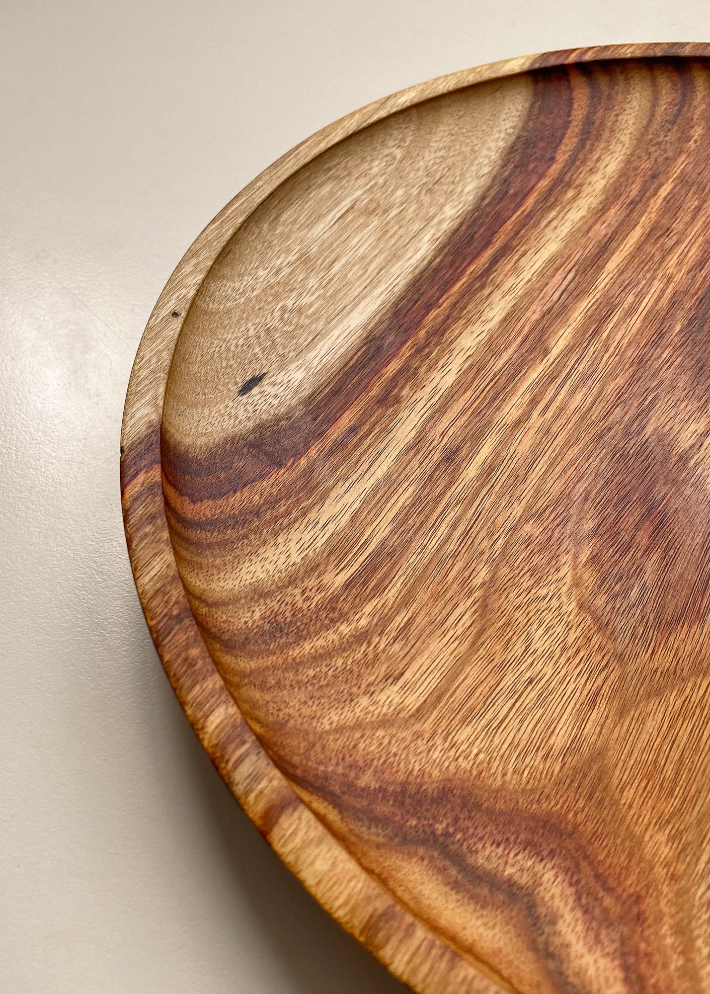 Close-up of orange wooden tray edge on white background.