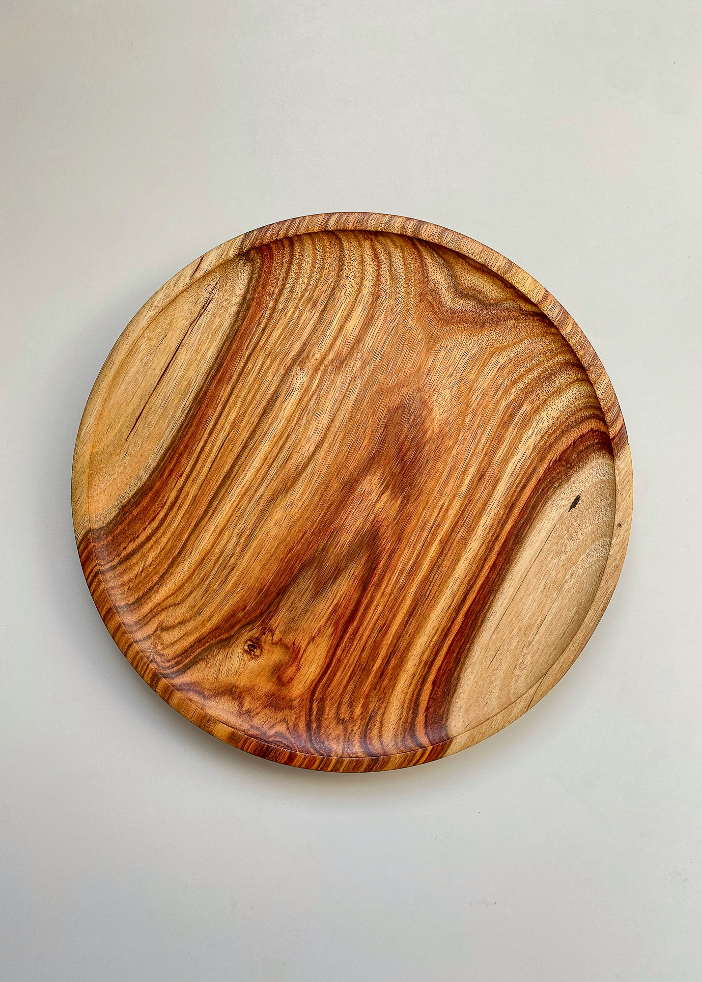 Top view of patterned orange wooden tray on white background.