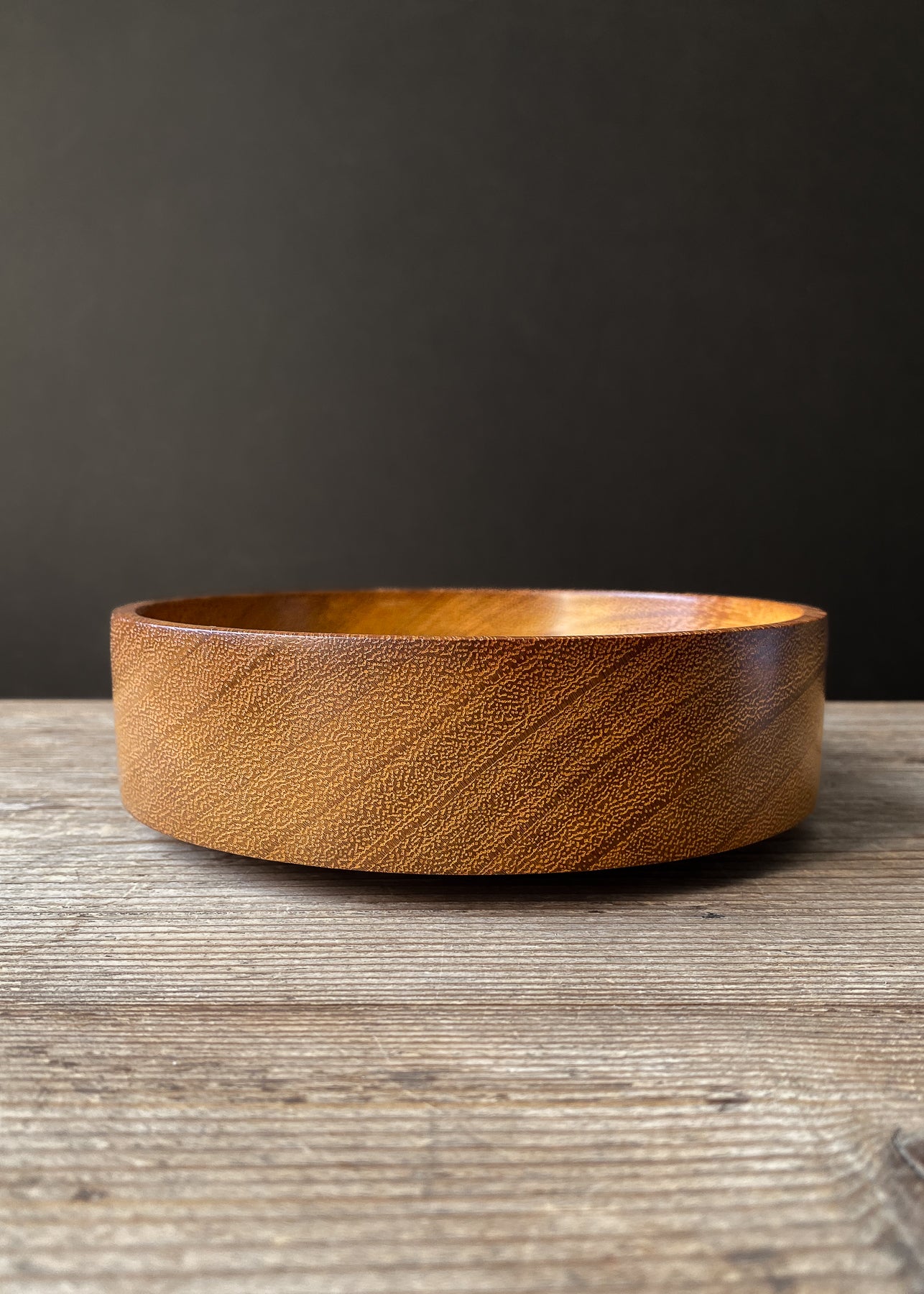 Iroko wooden bowl on wood table.