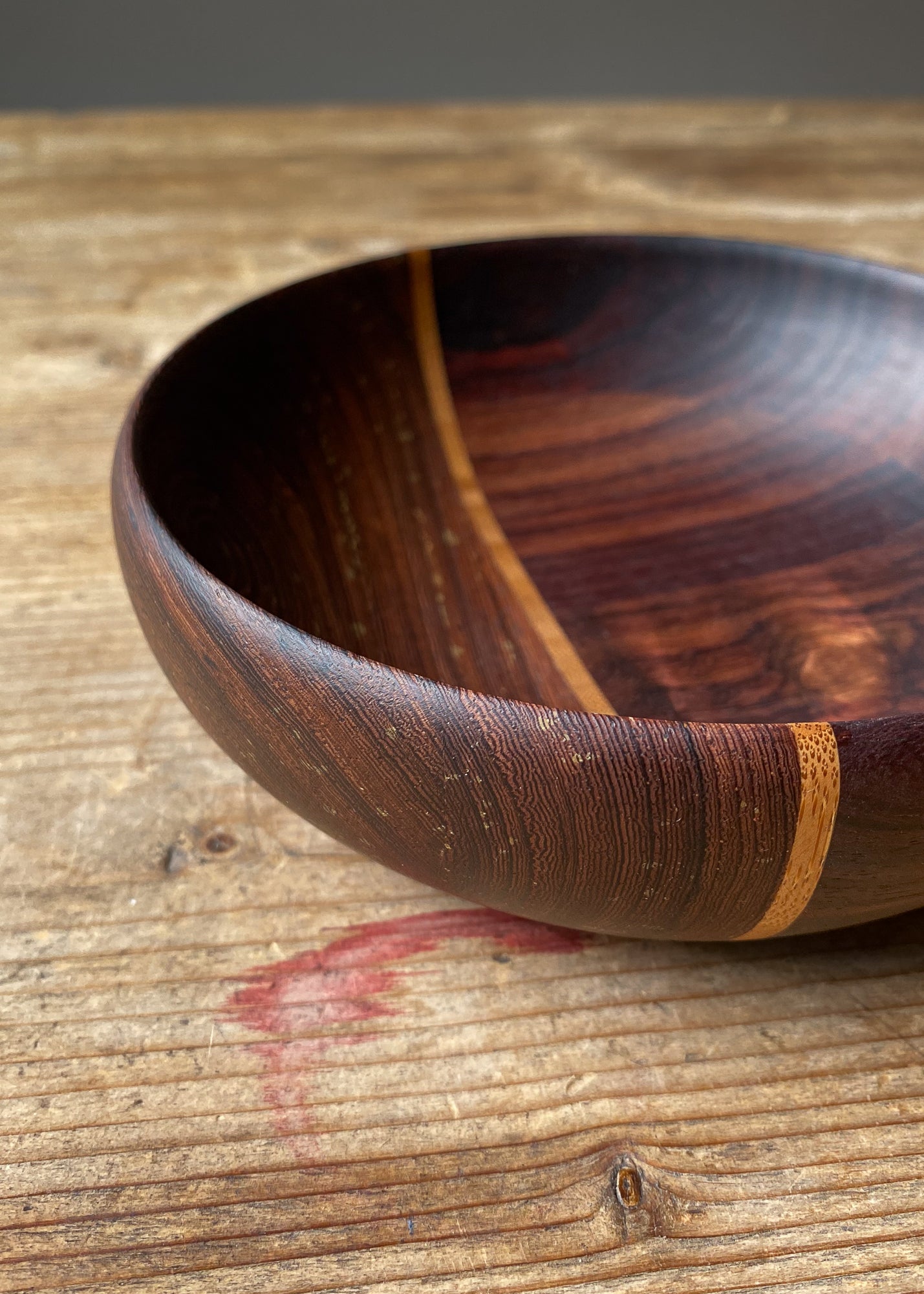 Close-up of segmented wooden bowl on wood table.