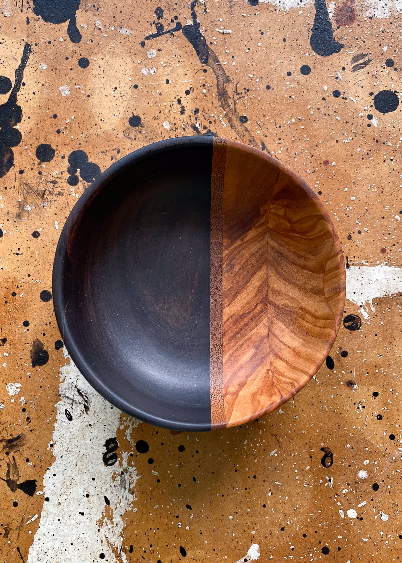 Top view of segmented wooden bowl on textured background.