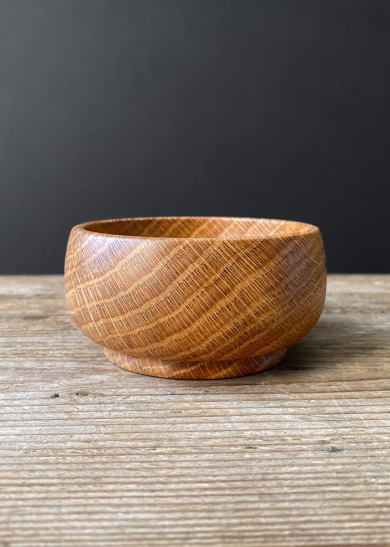 Small Oak wood bowl on wooden table.