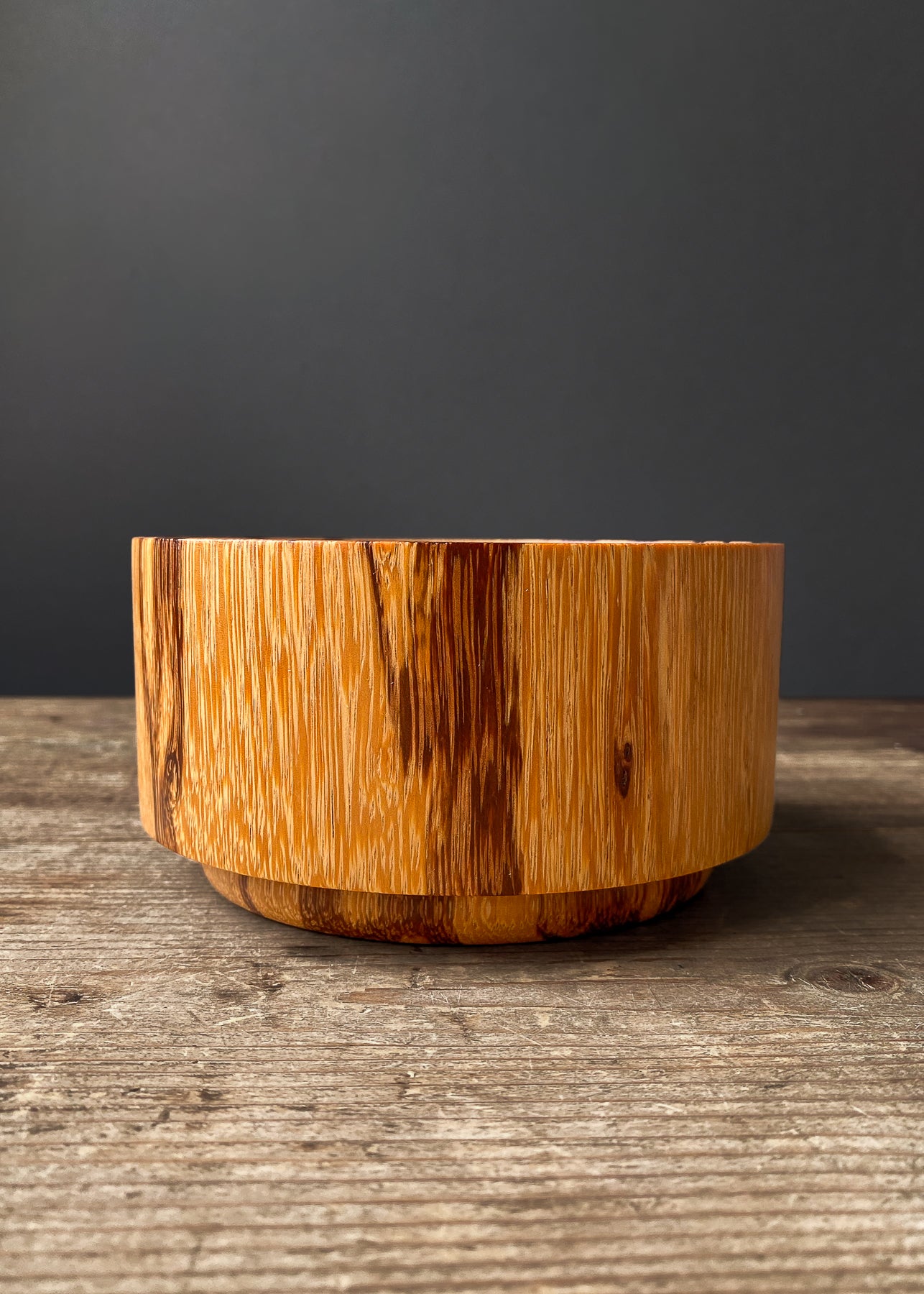 Patterned orange Marblewood wooden bowl on wood table.