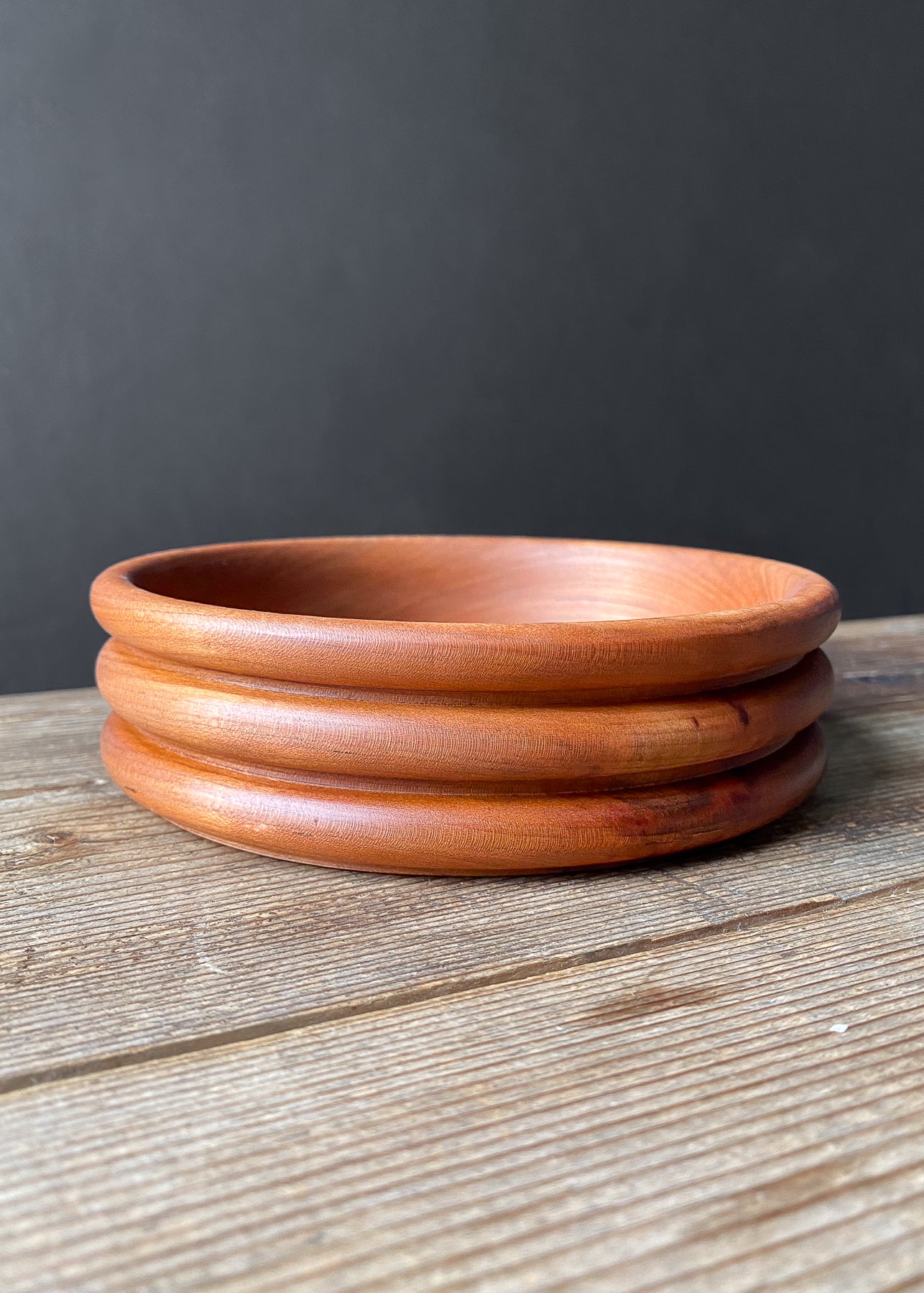 Cherry wood bowl on wooden table.