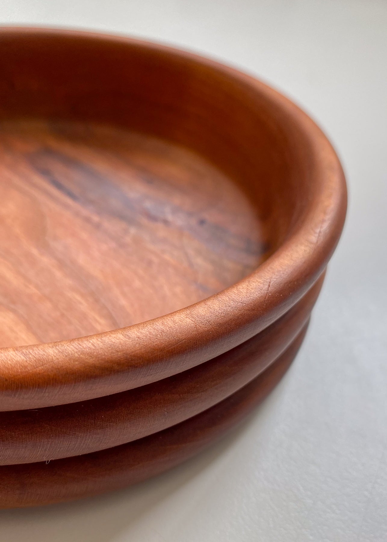 Close up inside view of Cherry wood bowl on white background.
