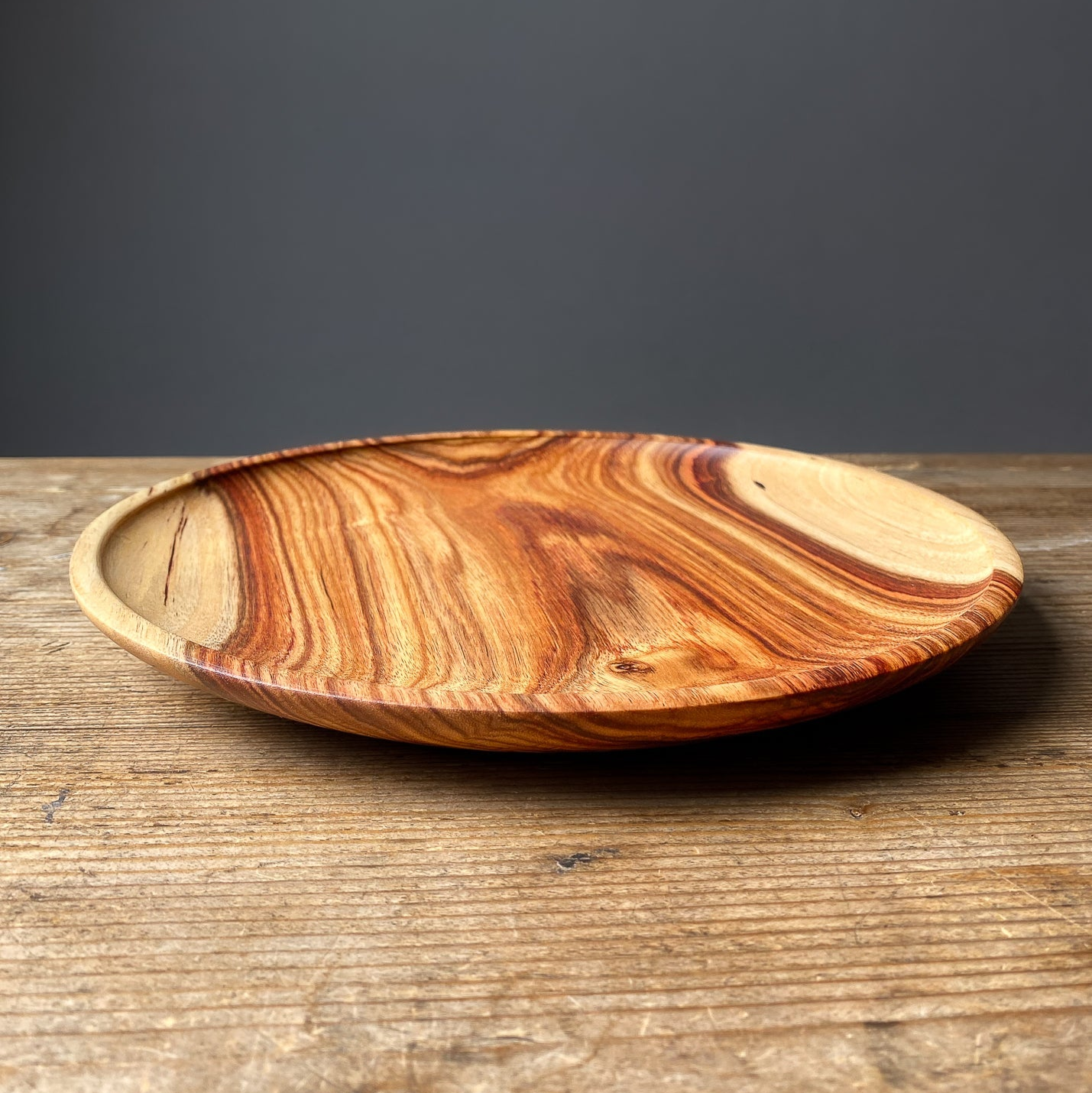Large orange wooden serving tray on wood table.