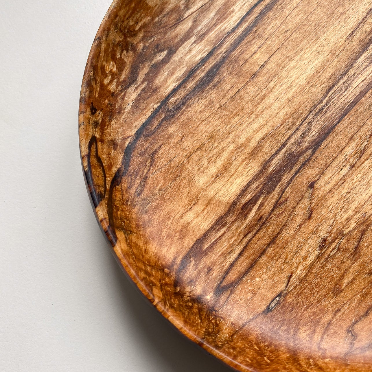 Close up view of Spalted Beech bowl against white background.